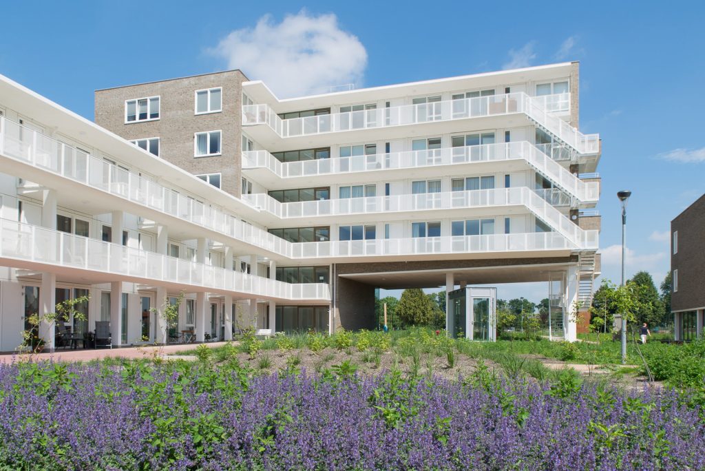 Gebouw met witte gallerijen met lavendel op voorgrond