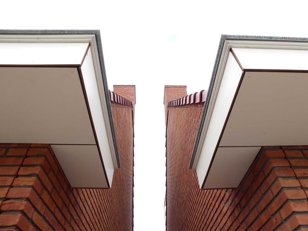 Havenbuurt Zaandam doorkijkje tussen twee huizen met dakgoten en rode baksteen