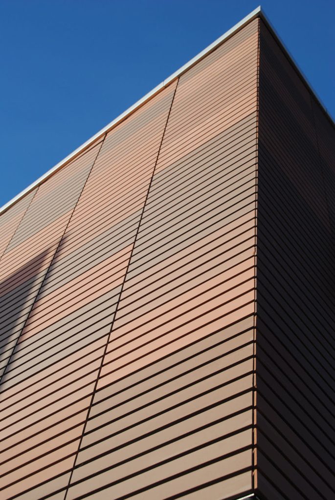 Hoek van een gevel met lichtbruine en oranjeachtig Argetontegels