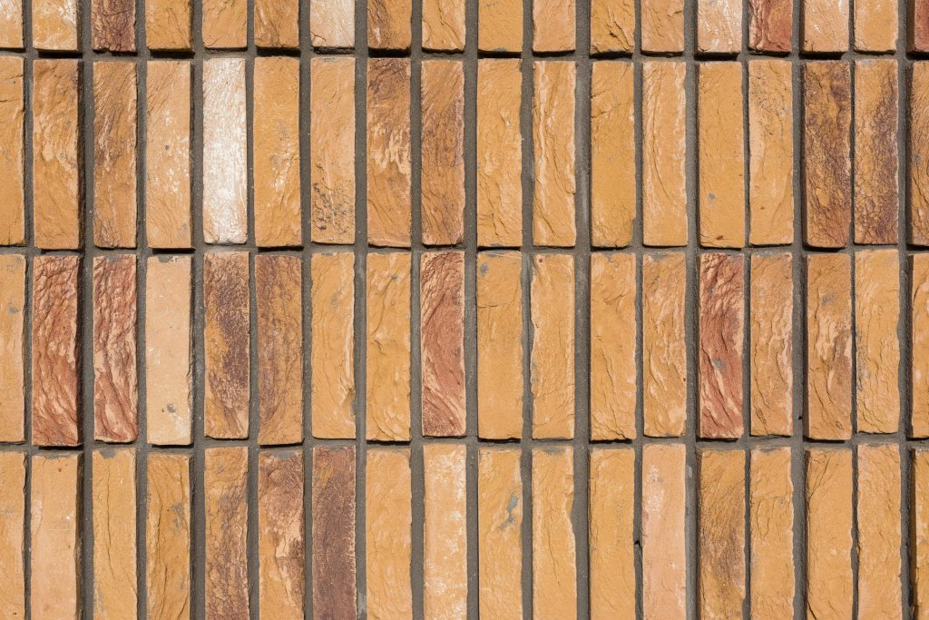 Detail van verticaal metselwerk met een gelige baksteen bij Hoornbeeck College in Rotterdam