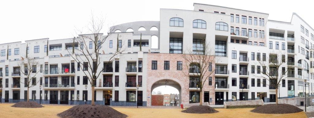 Gevel aan het maankwartier in Heerlen met prefab metselwerk en bomen op de voorgrond