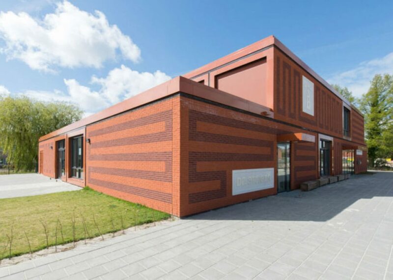 Rood gebouw met tekening in de gevel bij Lemstervaart