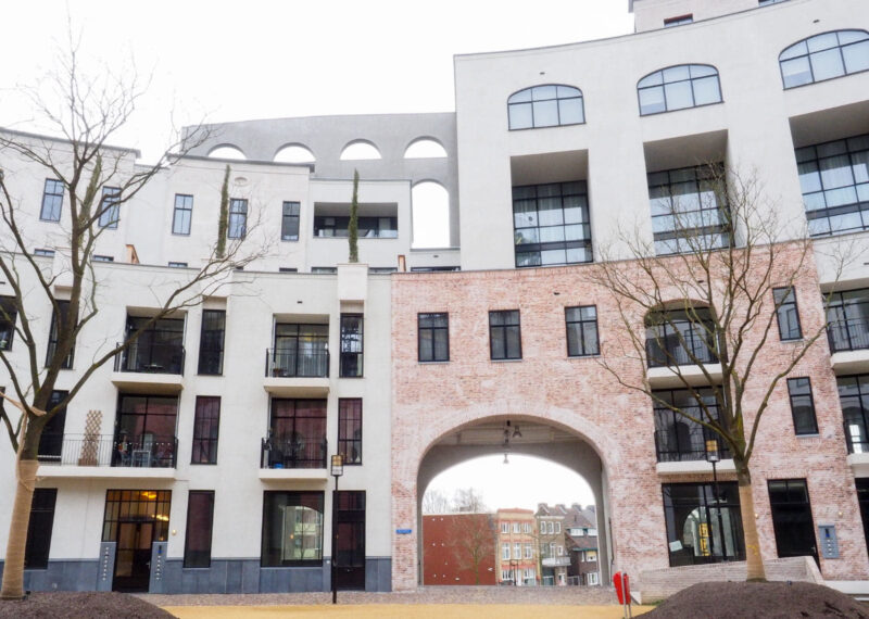 Zicht op een gebouw in wit en rood, met een boog van prefab in het midden