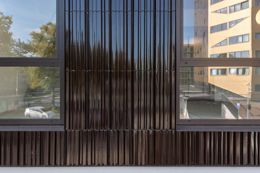 Detail van tegels van bruin argeton en ramen aan beide kanten