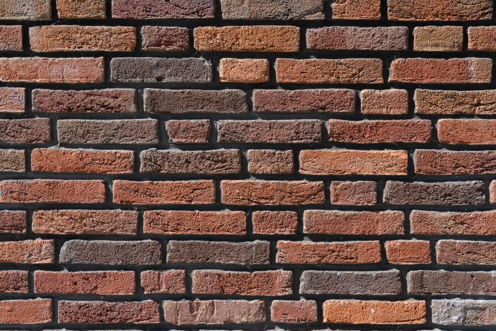 Roodbruine stenen muur van dichtbij bekenen