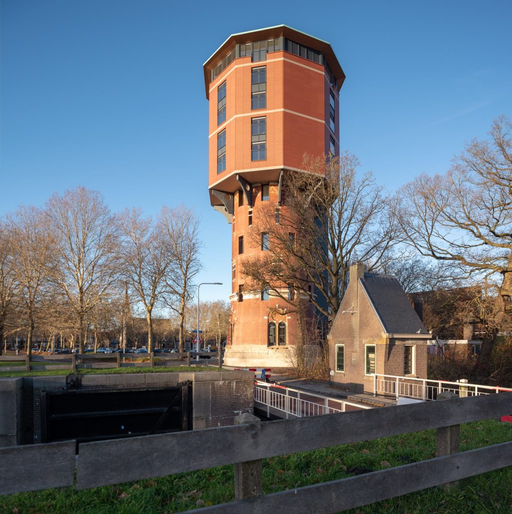 Zicht op Zwolse Watertoren met dijk en huisje op voorgrond