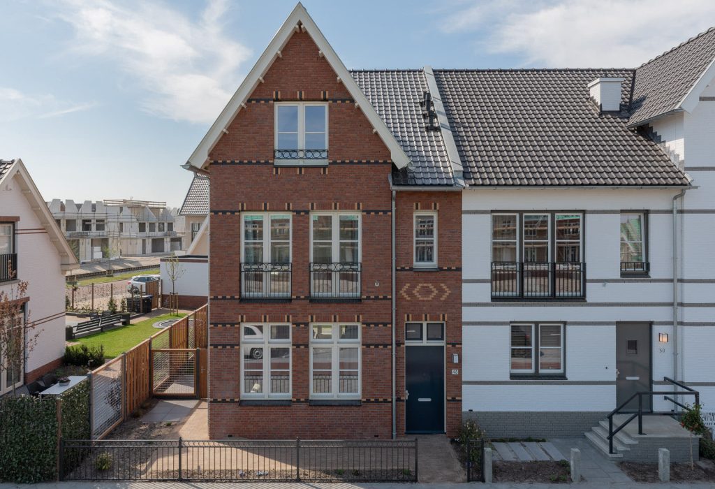Een rode hoekwoning met een rode steen