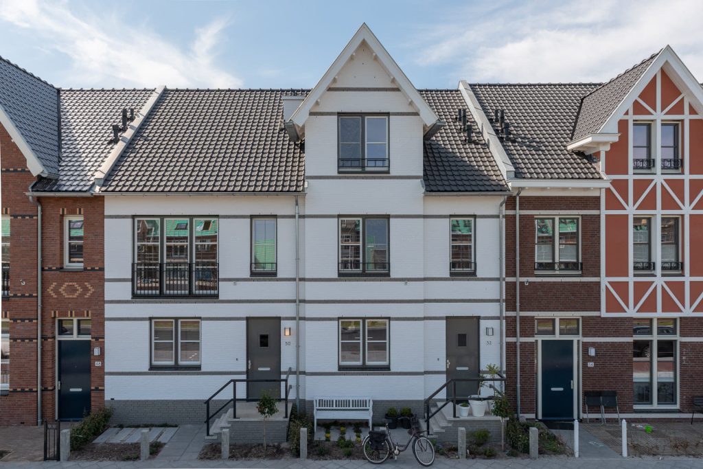 Witte tussenwoning met horizontale lijnen en een puntdak