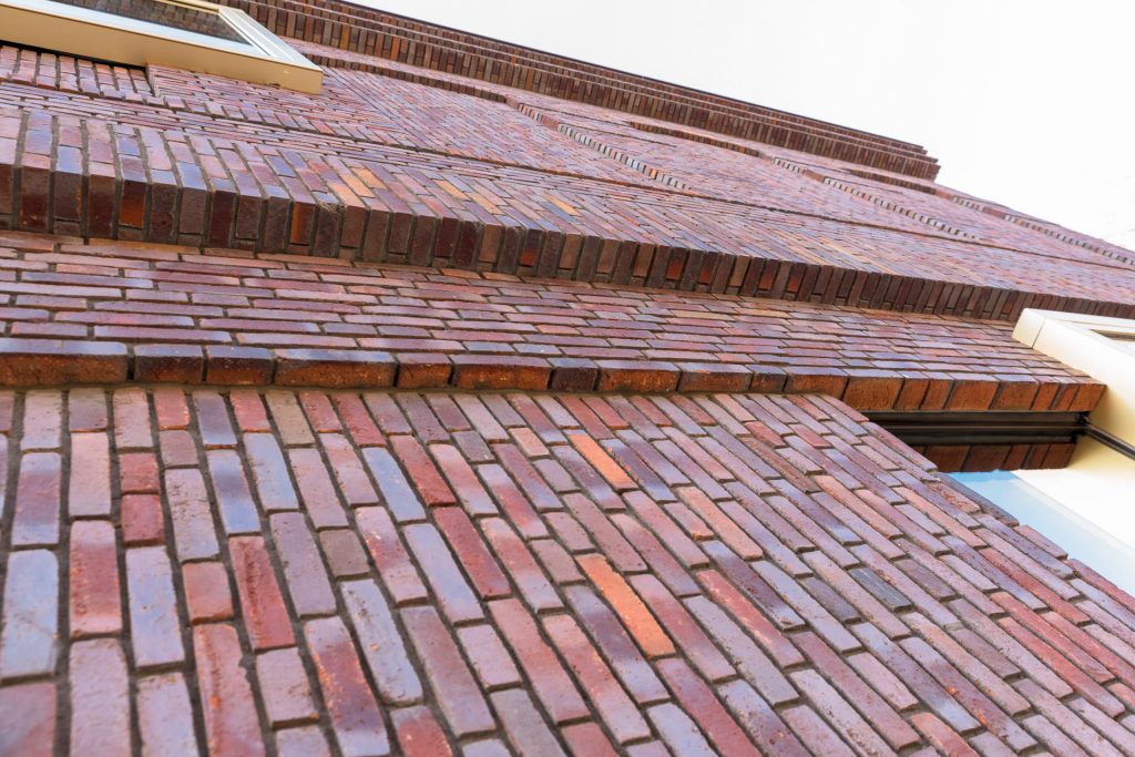 Muur met verschillende lagen stenen van de onderkant gefotografeerd.