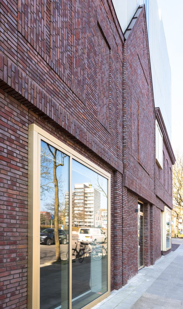 Muur van conservatprium in groningen, met gele grote raamkozijnen