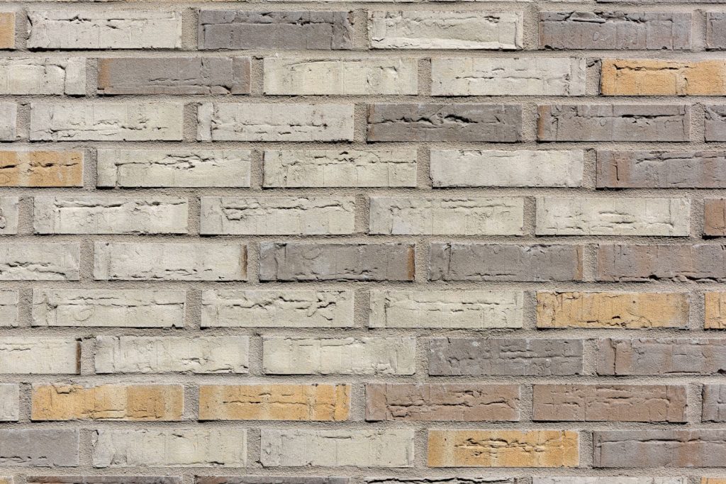 Een muur van dichtbij met gekleurde bakstenen