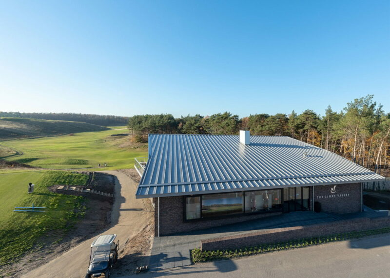 Uitzicht op een golfbaan met een gebouw op de voorgrond