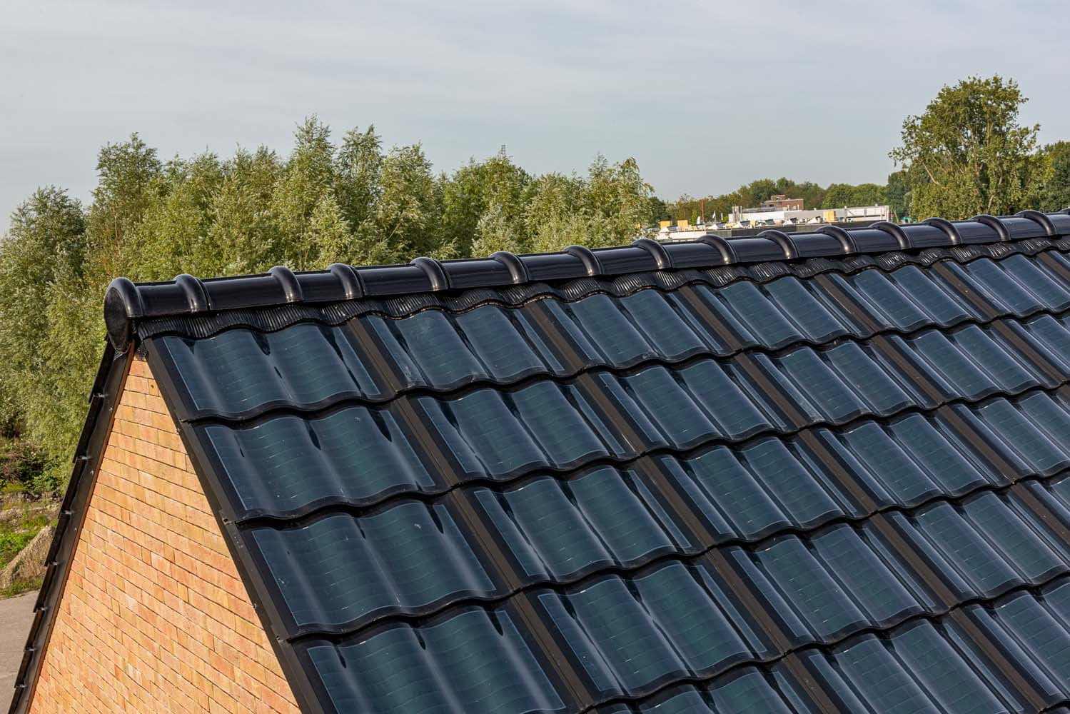 Nok van het dak met zonnepaneelpannen op de