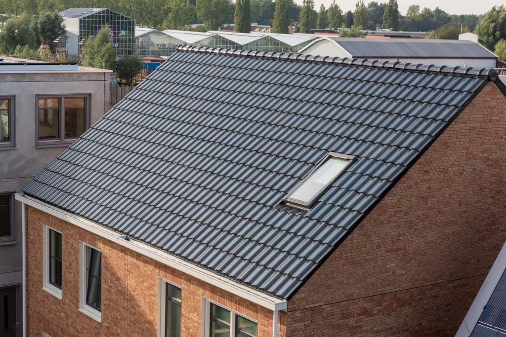 Dak van een twee-onder-een-kap woning met dakpannen van zonnepanelen op de loskade
