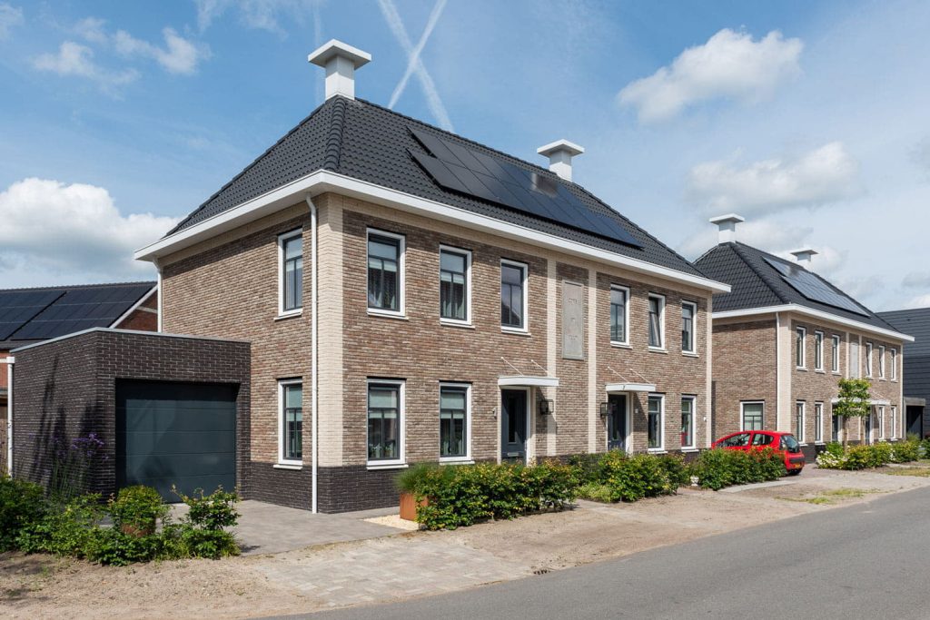 Een huis met lichte stenen en zwarte dakpannen