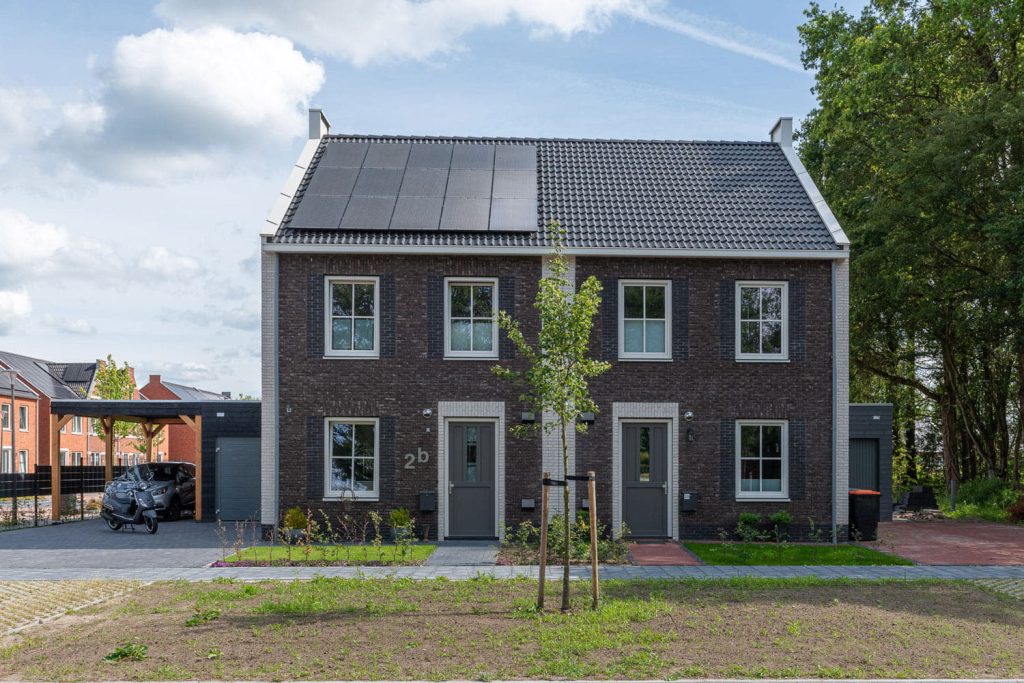 Een twee-onder-een-kap met donkere gevelstenen en donkere dakpannen