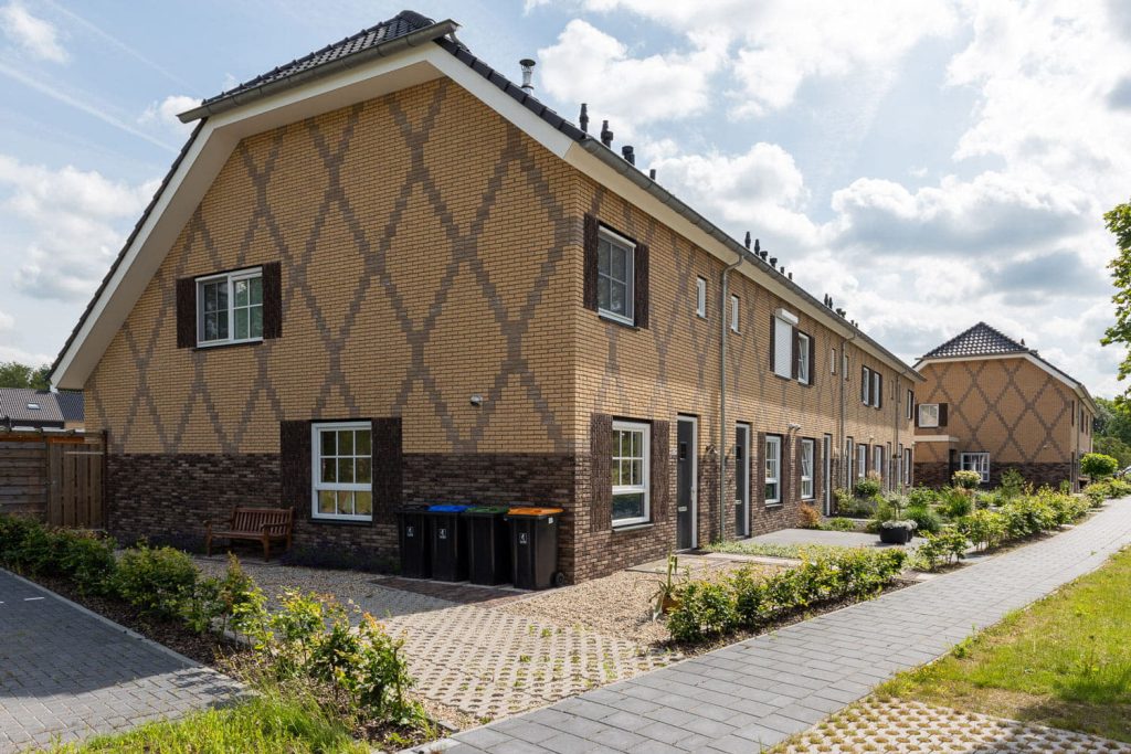 Rij met huizen met een lichtgele baksteen en kruizen in het metselwerk
