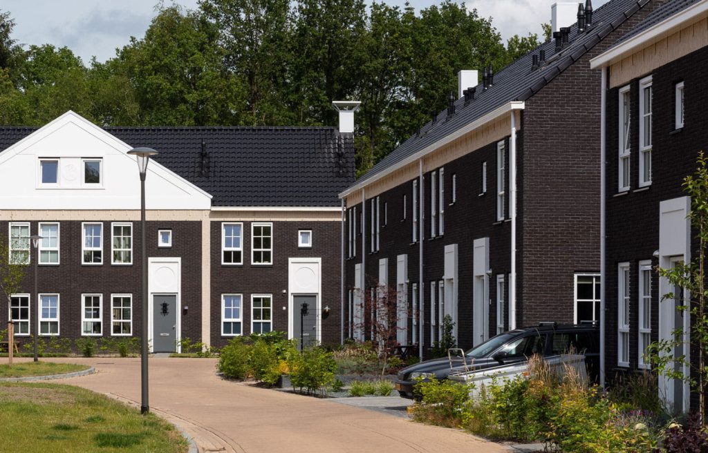 Een overzicht over woningen in een rij met een weg ervoor
