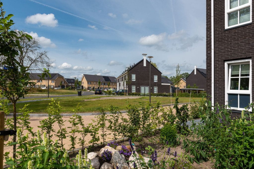 vergezicht over een nieuwe wijk met donkere bakstenen en dakpannen