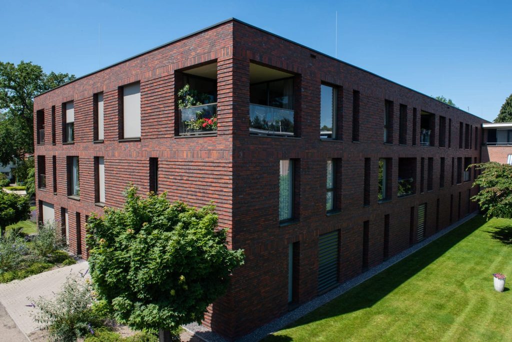 Zijaanzicht van een gebouw met roodbruine gevel en