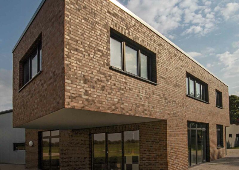 Hoek van een gebouw met bruine strips, ter illustratie van het gevelsysteem A-Brick