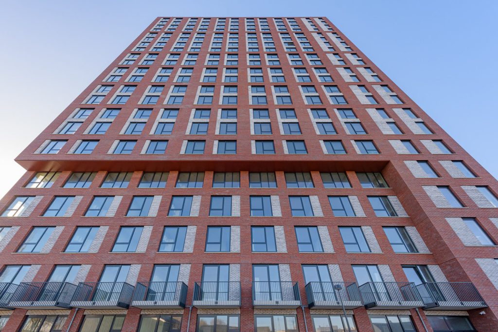 Gevel van een toren met rode gevelstenen van onderen naar boven bekeken