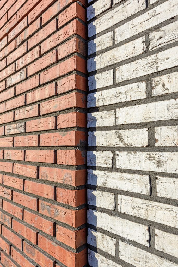 Detail van een muur met rode en lichte kleuren baksteen van zijkant bekeken