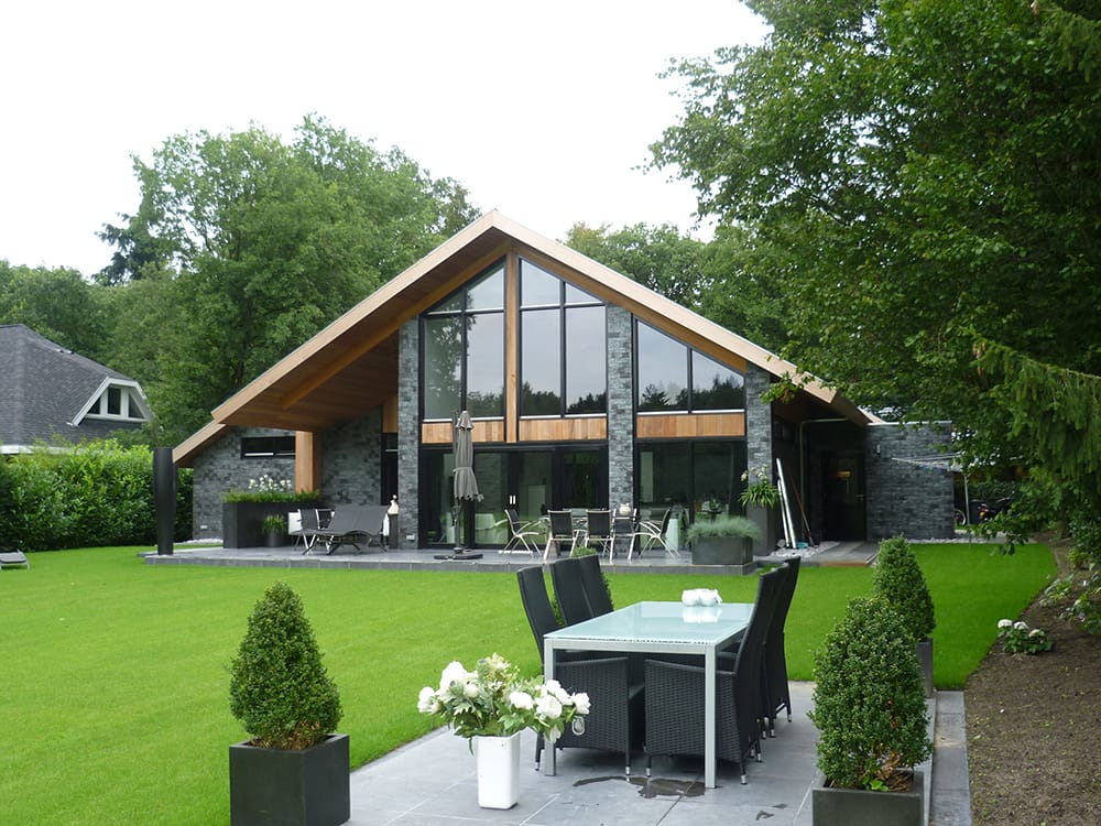 Vrijstaande woning met donkere ClickBrick en houtkleurige accenten met een tuin op de voorgrondVrijstaande woning met donkere ClickBrick en houtkleurige accenten met een tuin op de voorgrond