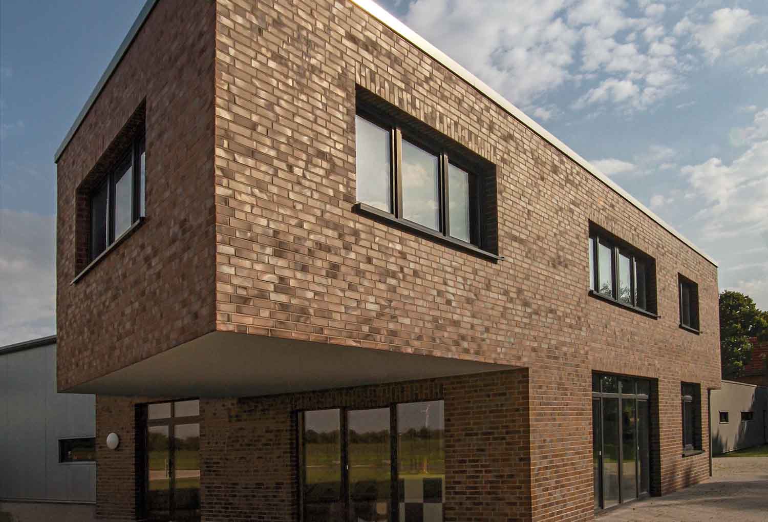 Hoek van een gebouw met bruine strips, ter illustratie van het gevelsysteem A-BrickHoek van een gebouw met bruine strips, ter illustratie van het gevelsysteem A-Brick