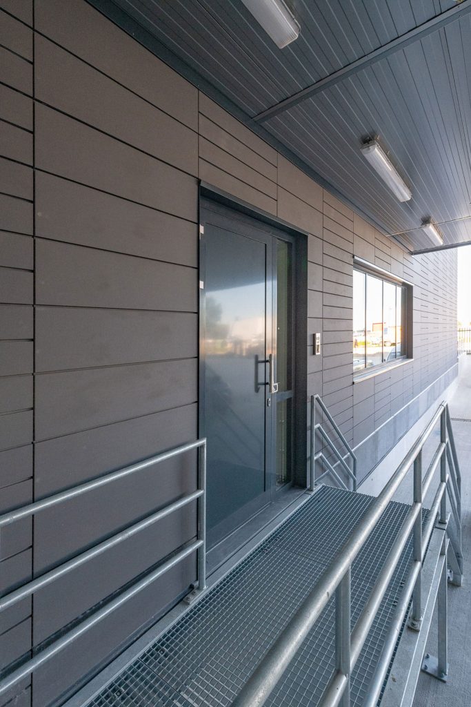 Een muur met een trap en deur, op de gevel argeton