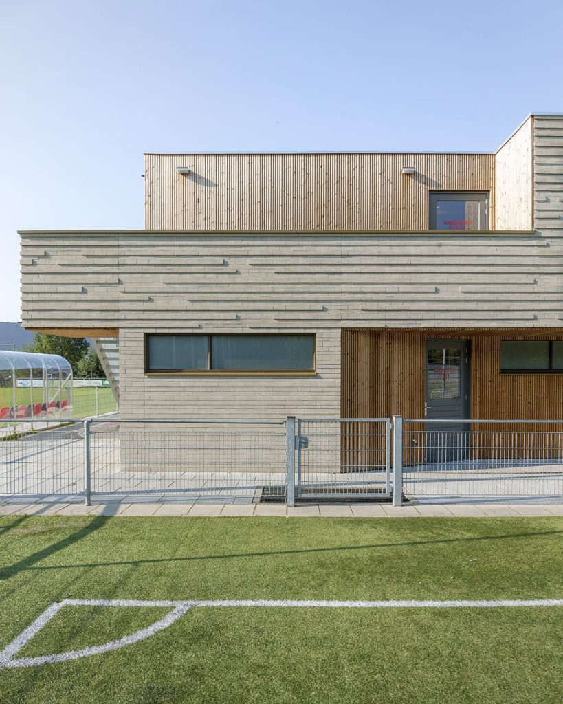 Gevelbekleding sv de meer met uitstekend metselwerk en voetbalveld
