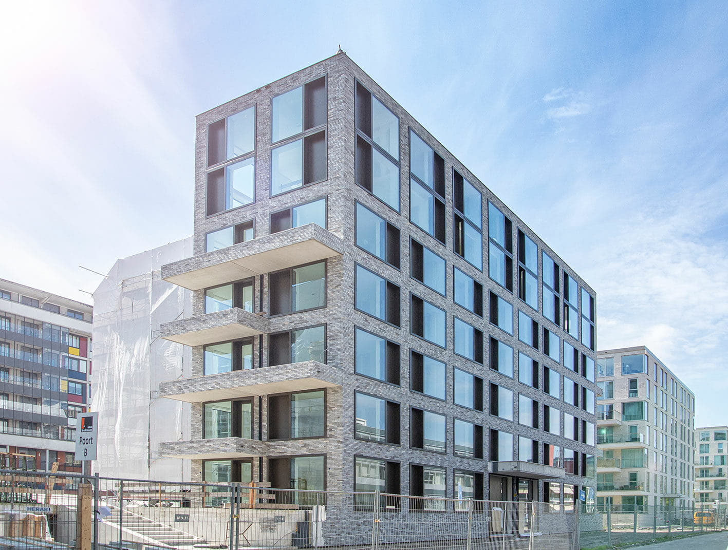 Gevel van hoogbouw met grijze steenstrip op het systeem van Sto