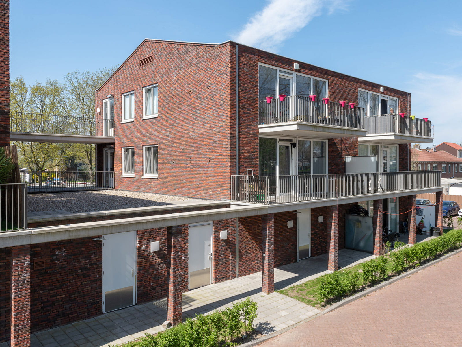 Foto van een roodbruin gebouw op dezelfde hoogte, met balkons en een overkapping