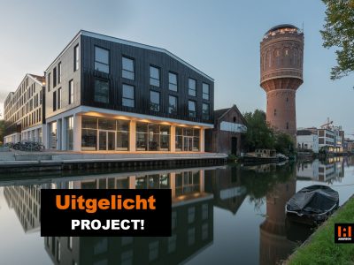 Donker gebouw aan een rivier met ernaast een watertoren en een bootje op het water